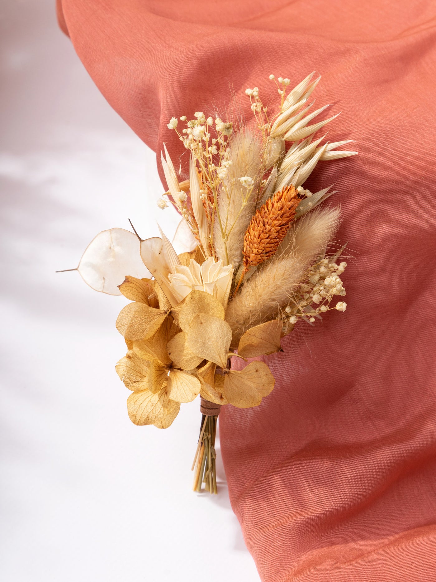 Boutonniere with terracotta rose flower for groom in boho style