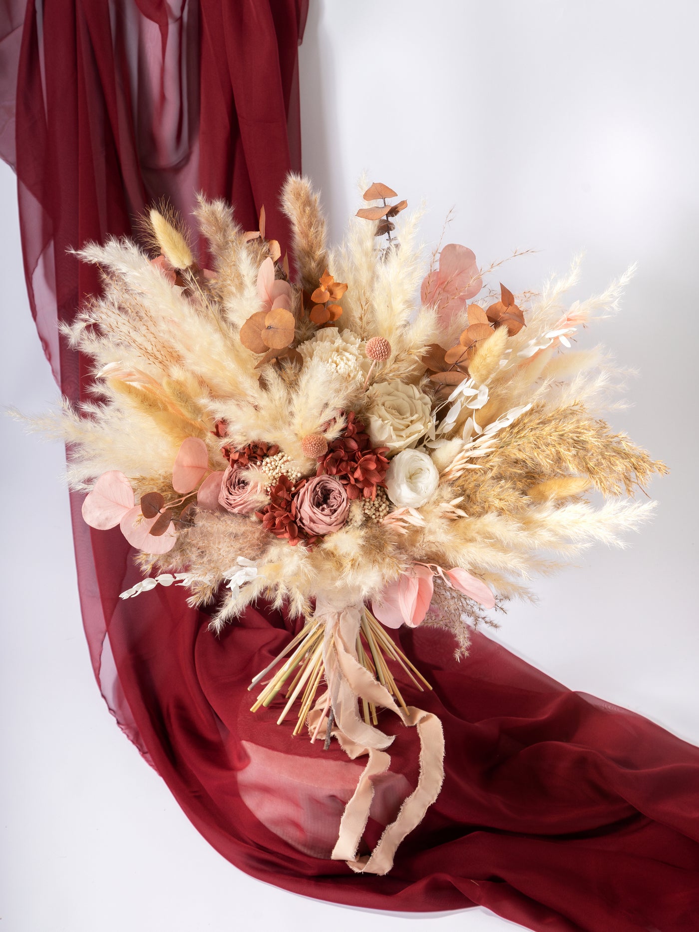 Bridal bouquet with dusty rose flowers, pampas grass, and eucalyptus