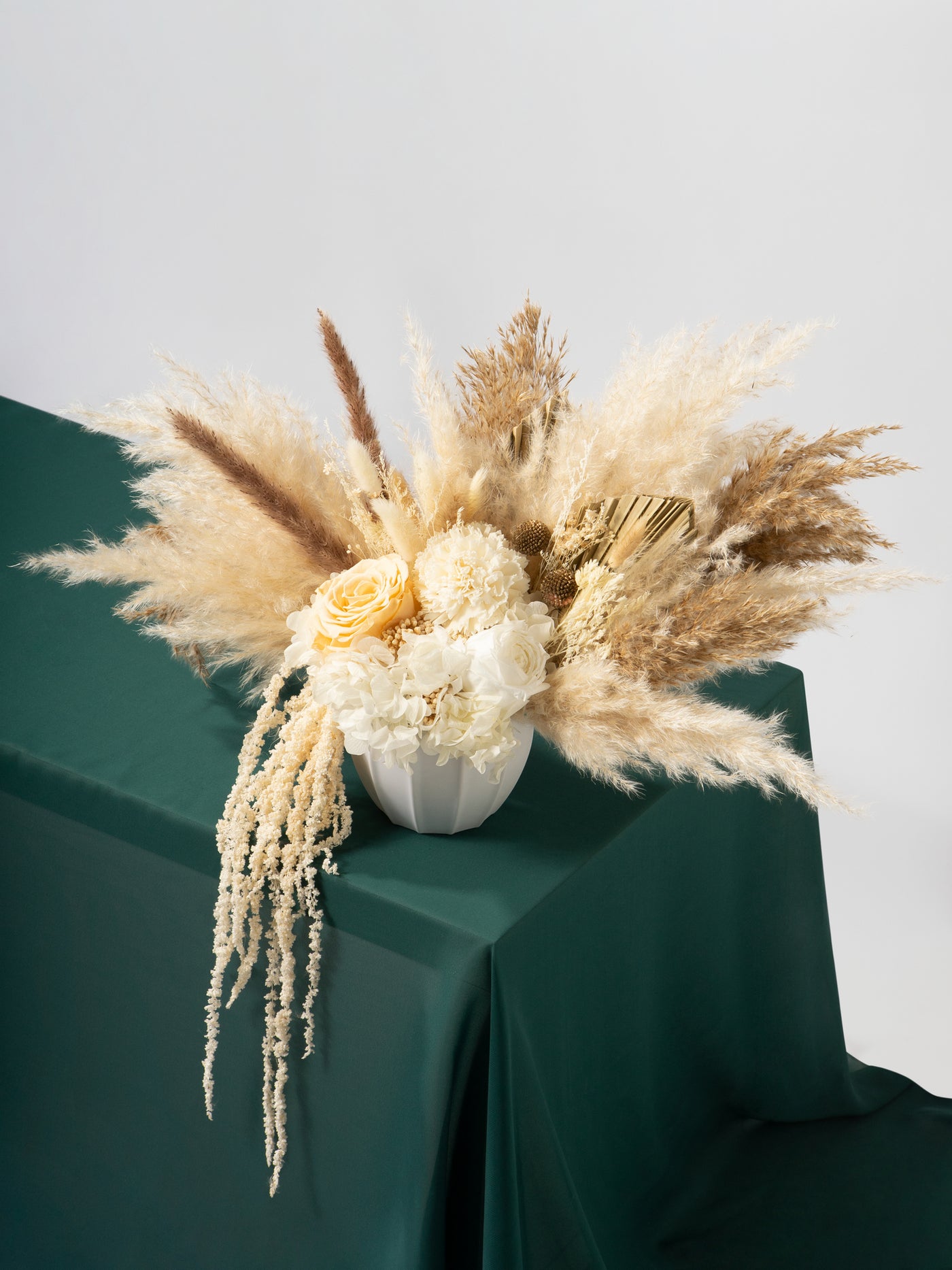 Centerpiece with white, cream roses, beige dried grass on boho wedding