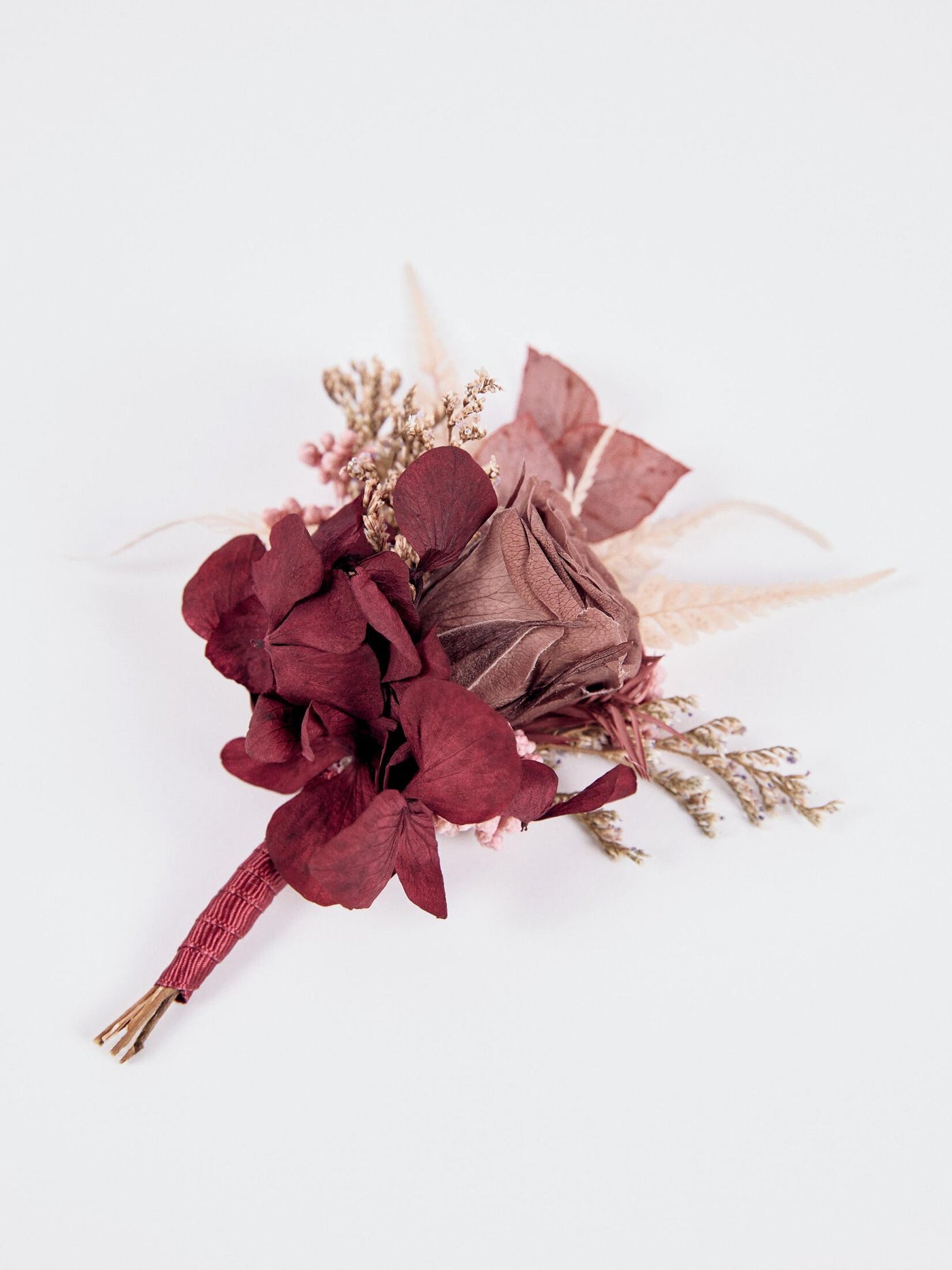 boutonnniere with flowers and rose on white background