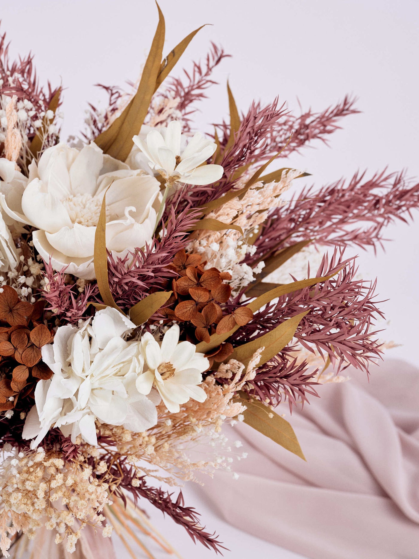 bouquet with flowers near a purple fabric