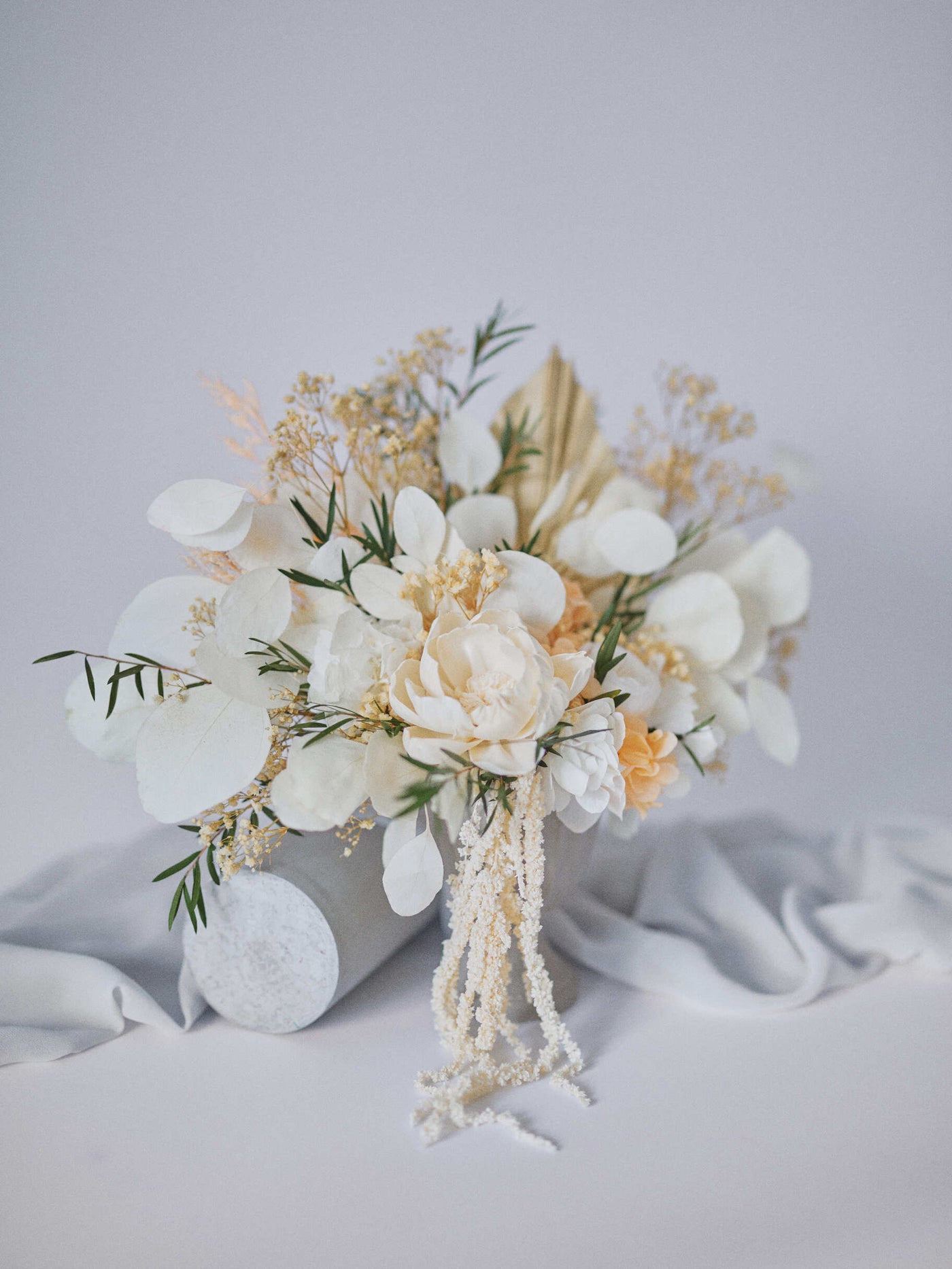 small centerpiece is standing near grey fabric on white background