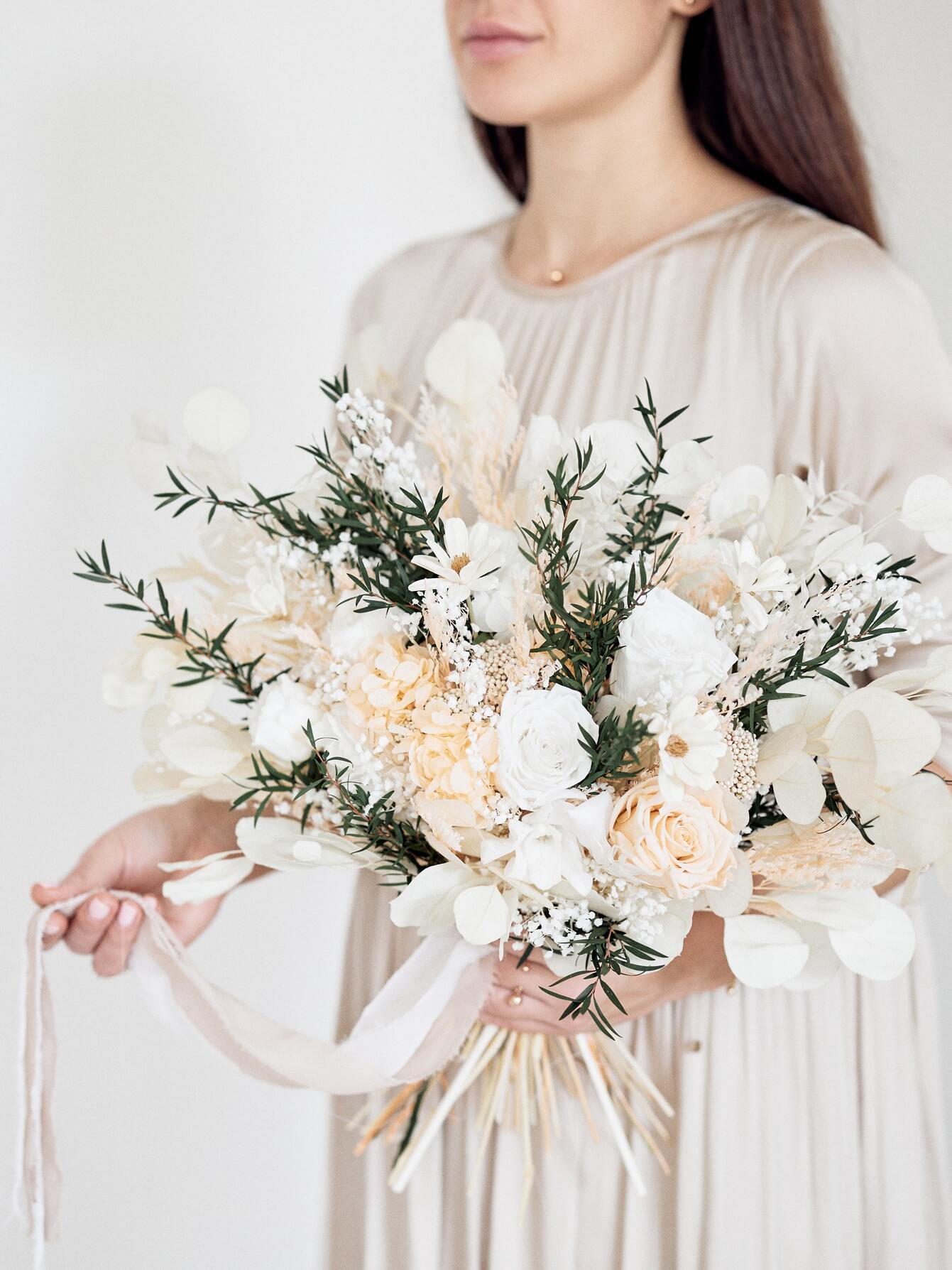 Girl with bridal bouquet in white and greenery colors