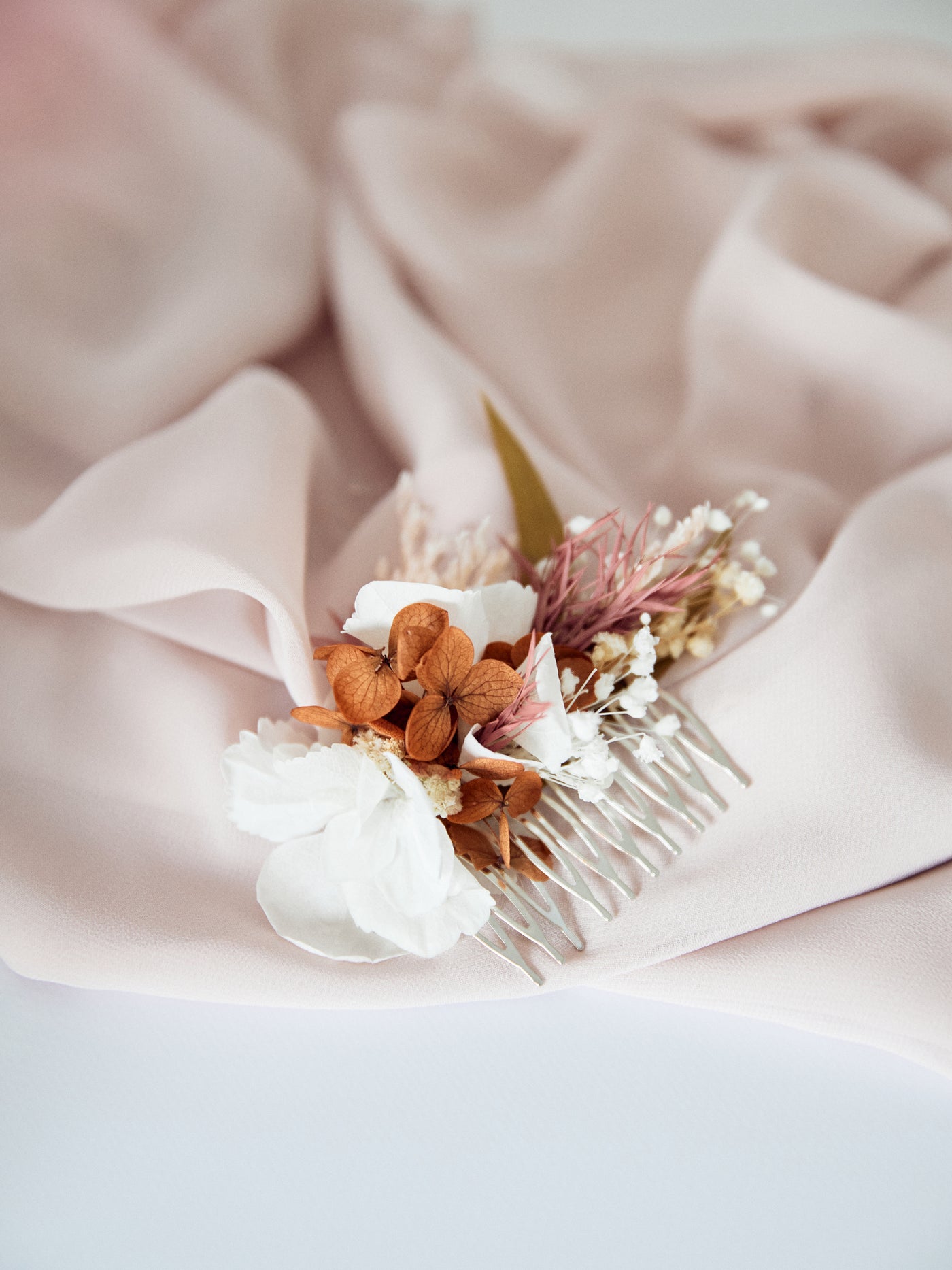 hair comb is lying on purple fabric and white background, close up view