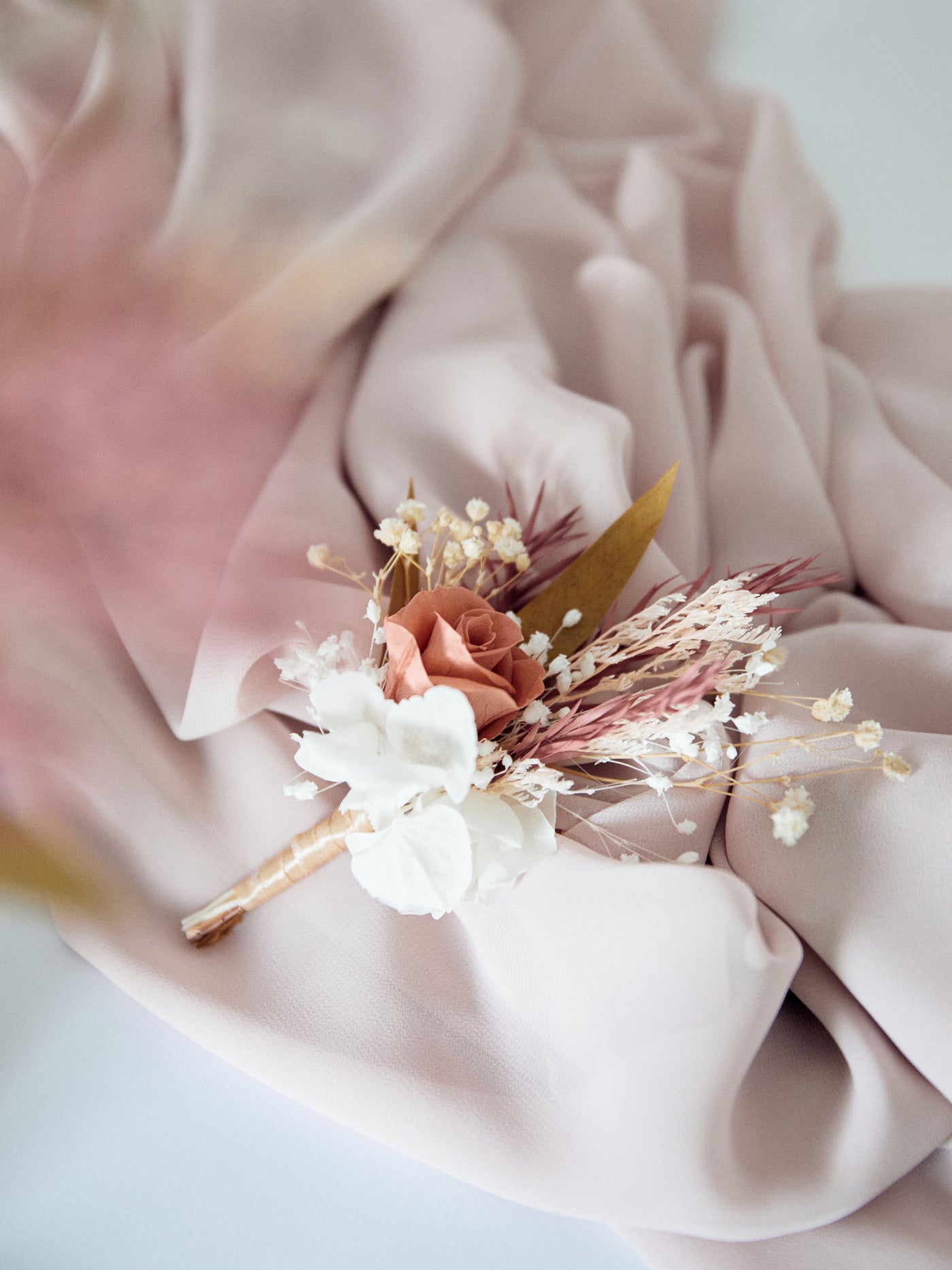 boutonniere is lying on a purple fabric