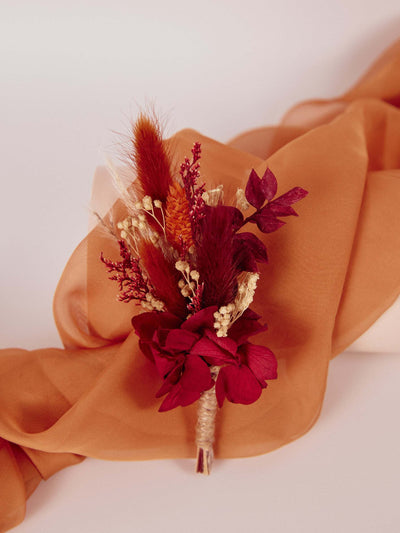 boutonniere is lying on terracota organza fabric