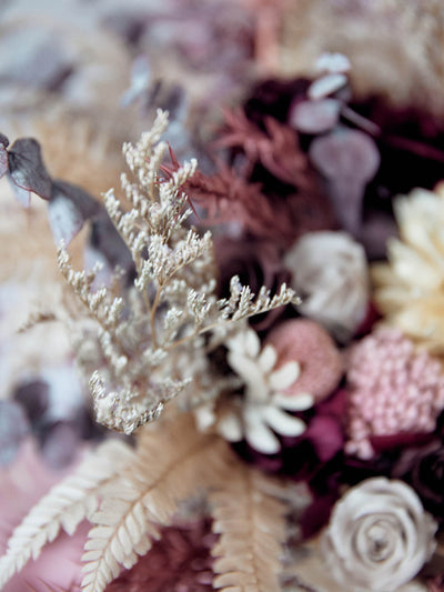 wedding bouquette with dried burgundy and beige flowers close up sign