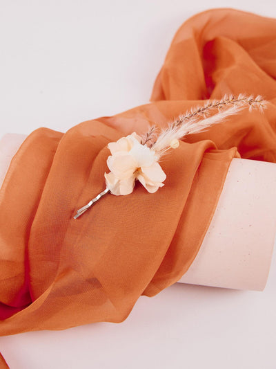 boutonniere lying on the orange fabric 2