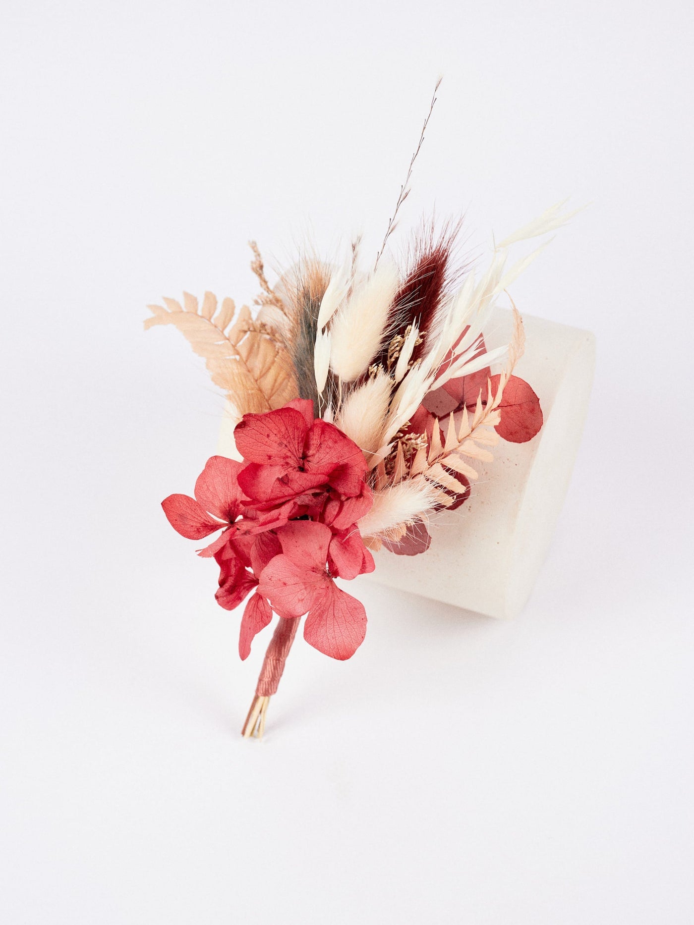 boutonniere the boutonniere is leaning on a white stand on a white background