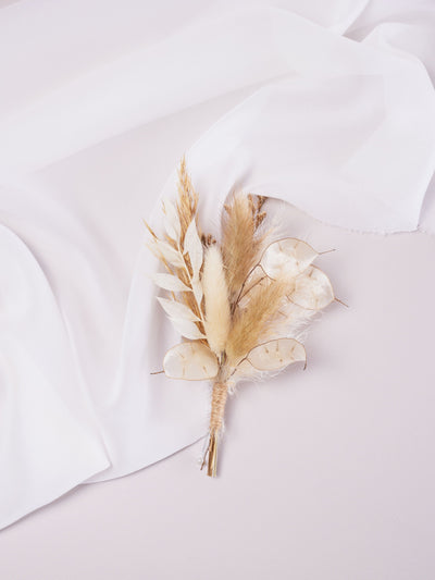 wedding boutonniere is lying on white organza and white background