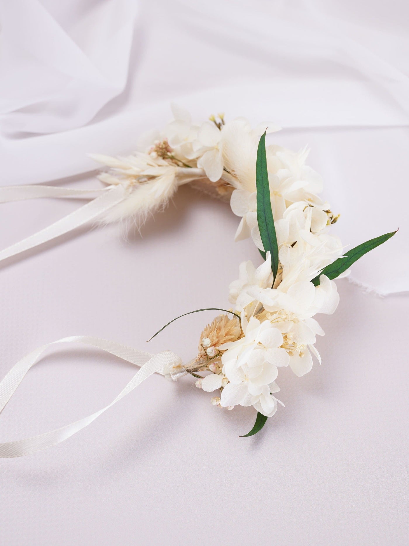 corsage is lying on white background near white organza