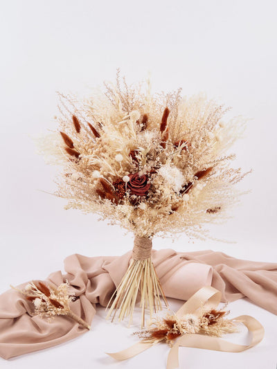 corsage is lying on white background near boutonniere on beige fabric and wedding bouquet which standing