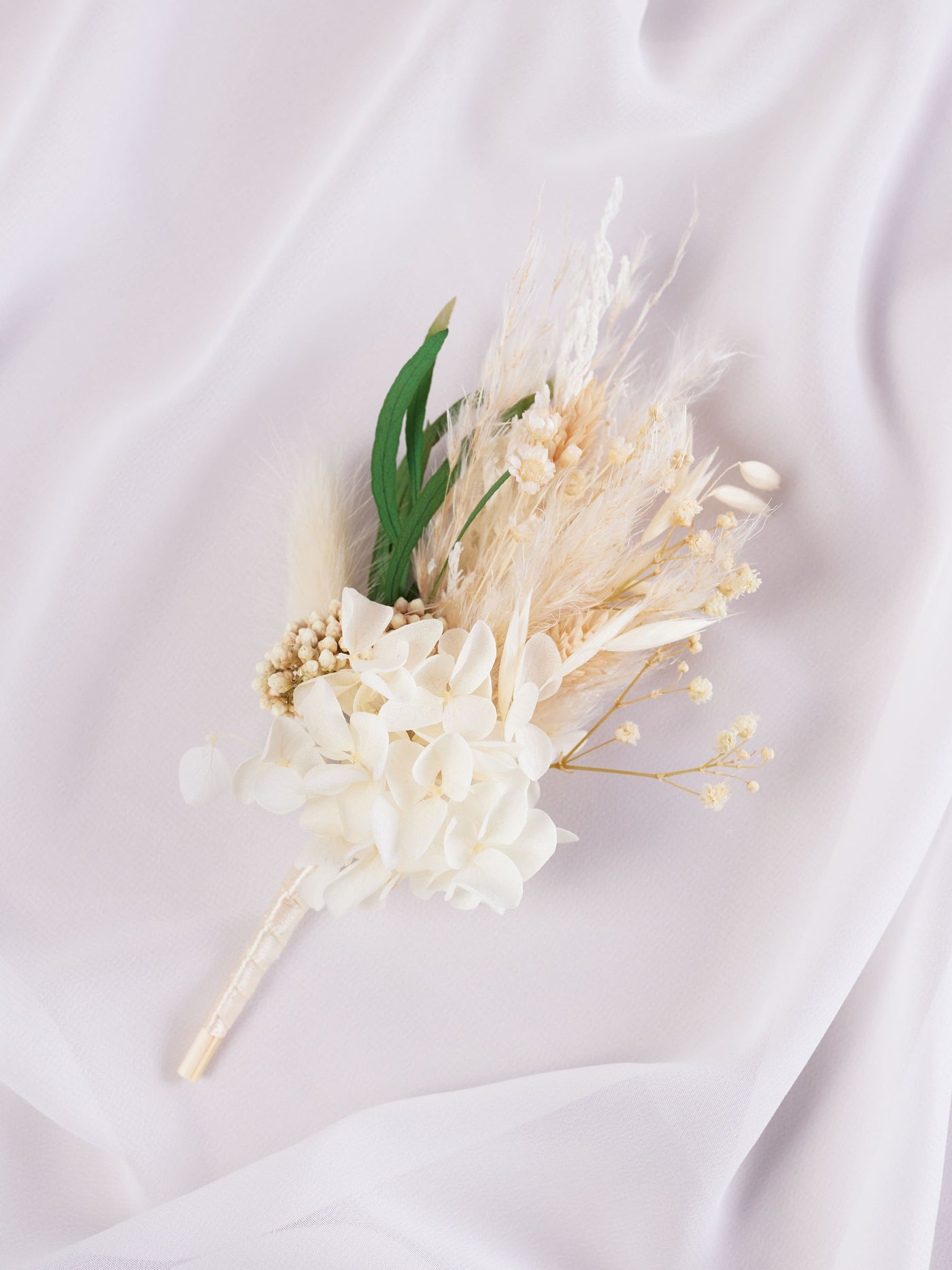 boutonniere is lying on white organza