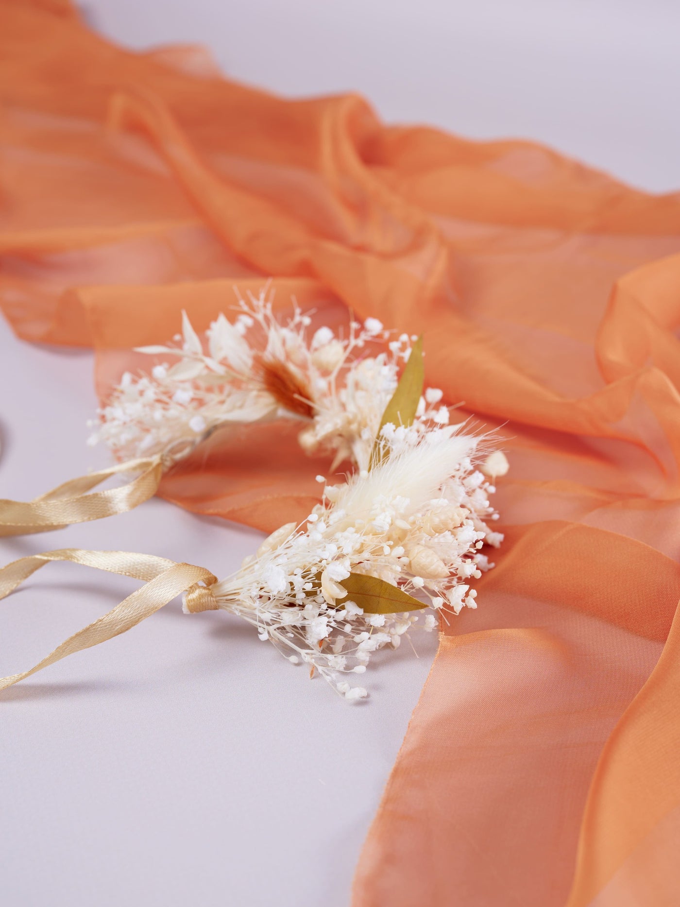 corsage is lying on orange organza and white background 2