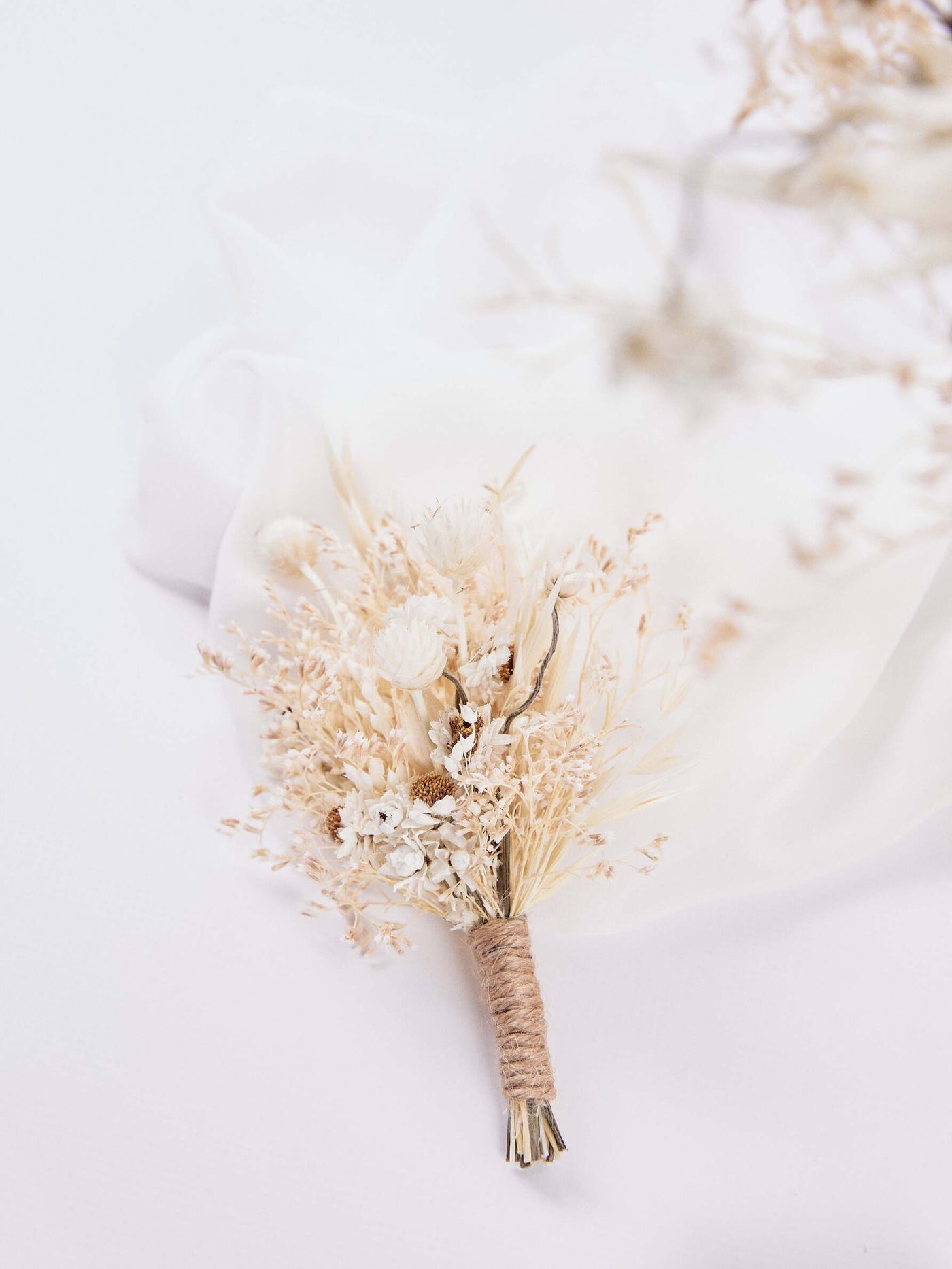 boutonniere is lying down on white background and silk