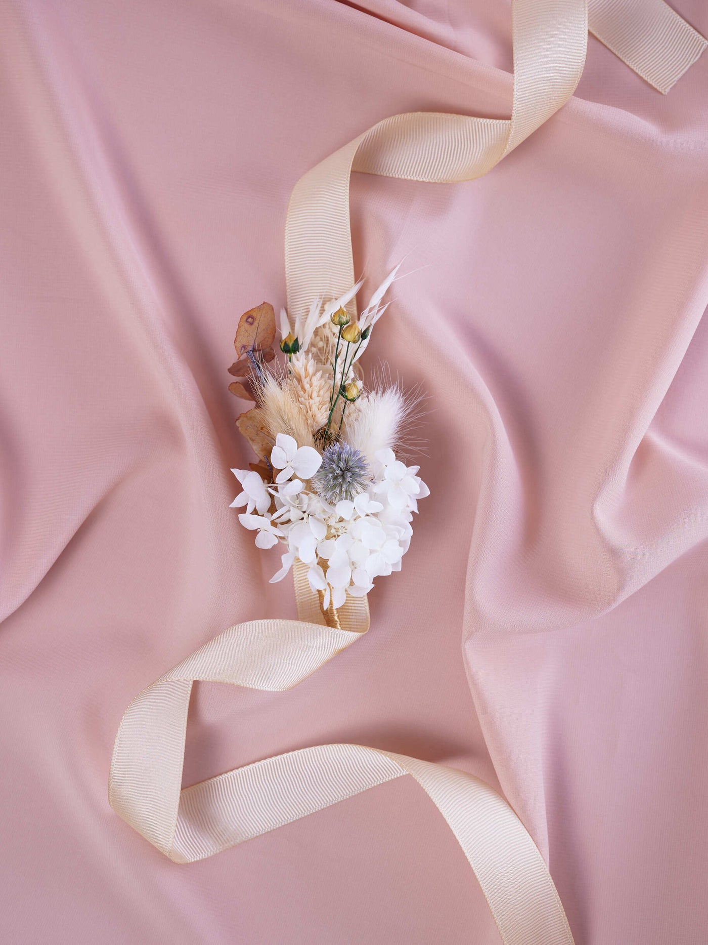 corsage is lying on pink fabric