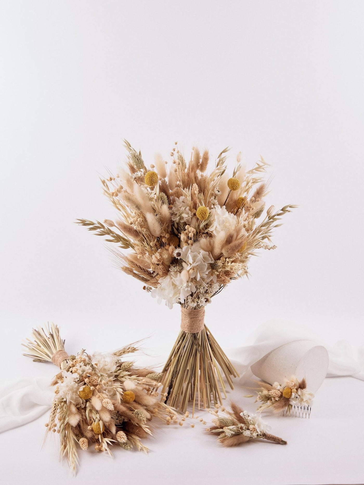 haircomb is lying on white background near standing wedding bouquet, boutonniere and lying bouquet