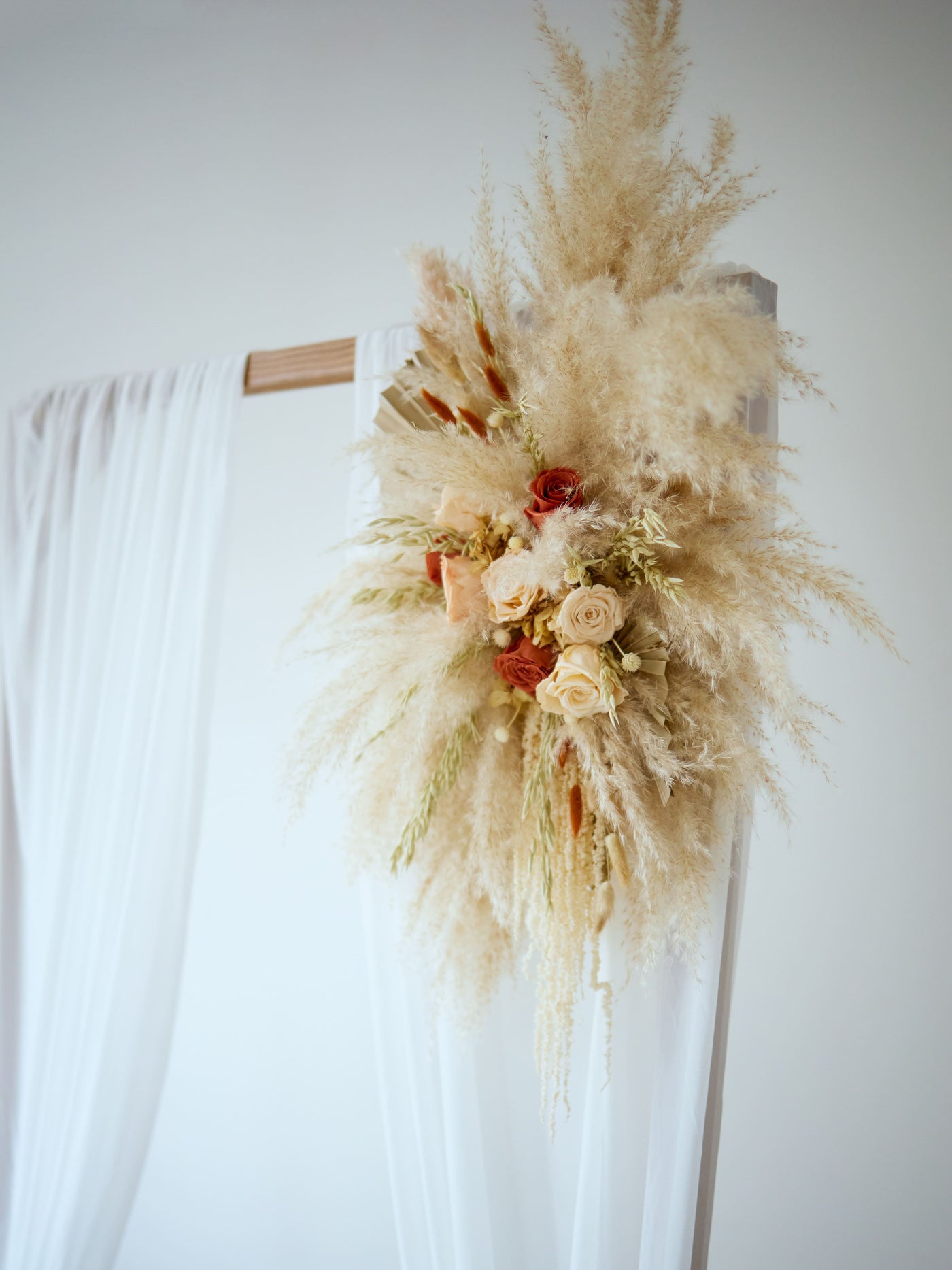 arch flowers bouquet is higning on wedding arch with white blinds