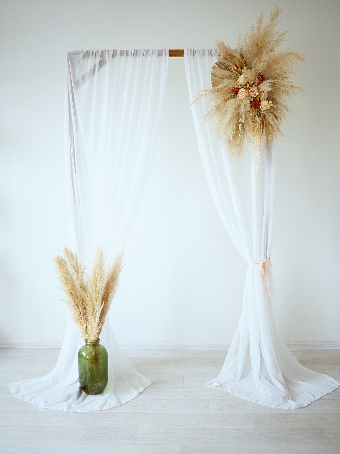 arch flowers bouquet is hanging on wedding arch with white blinds