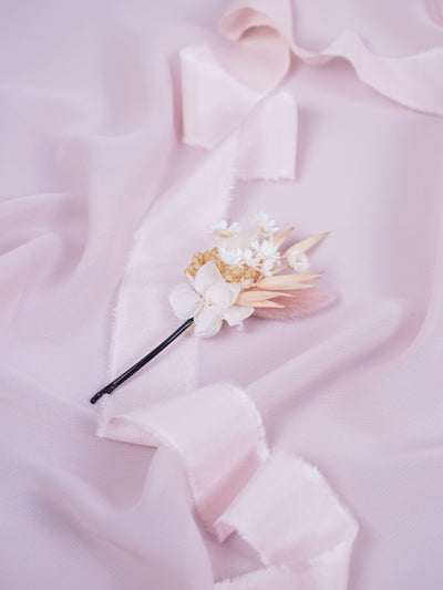 bobby pin is lying on white ribbon and light pink organza