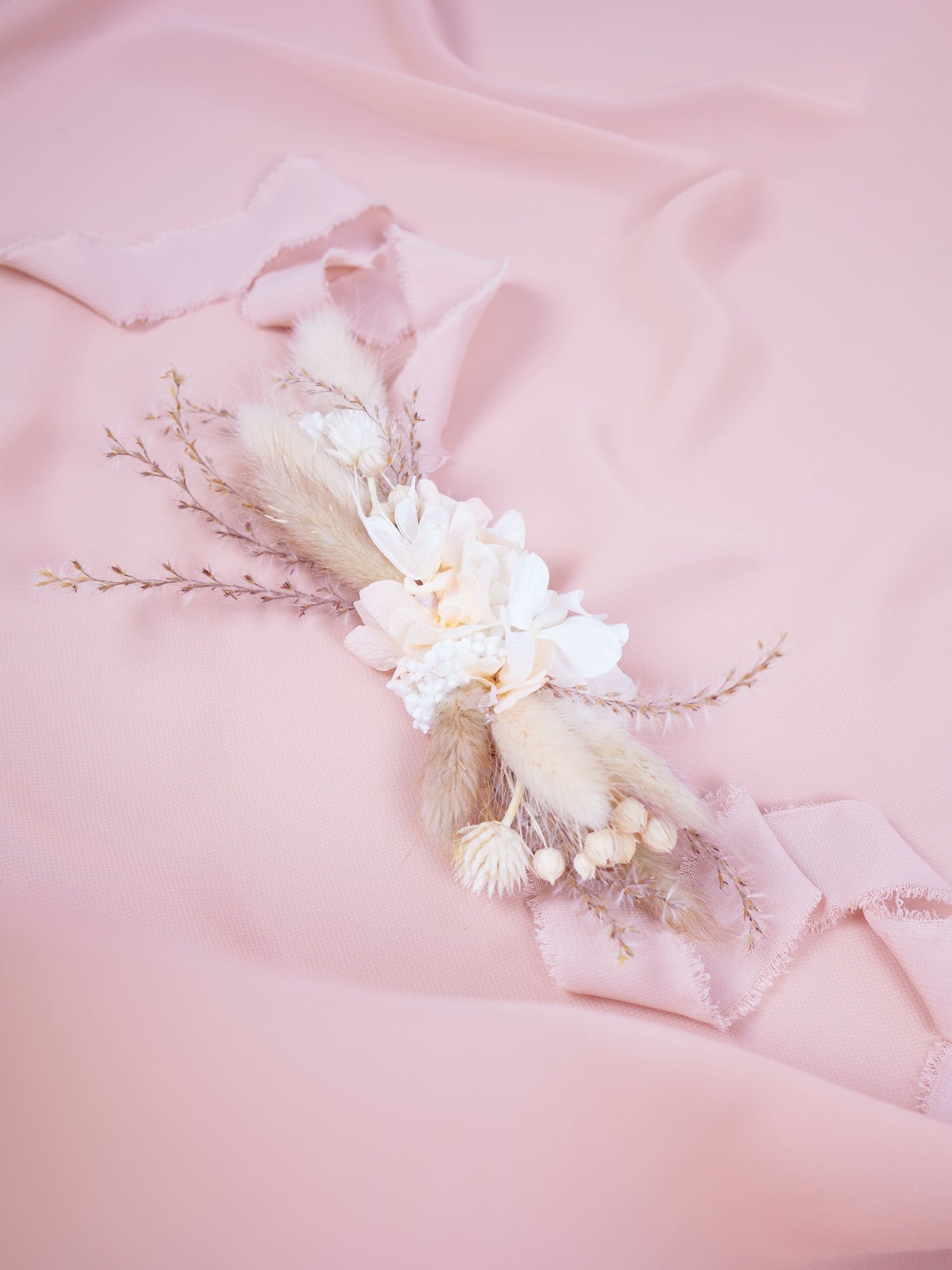 corsage is lying on pink organza