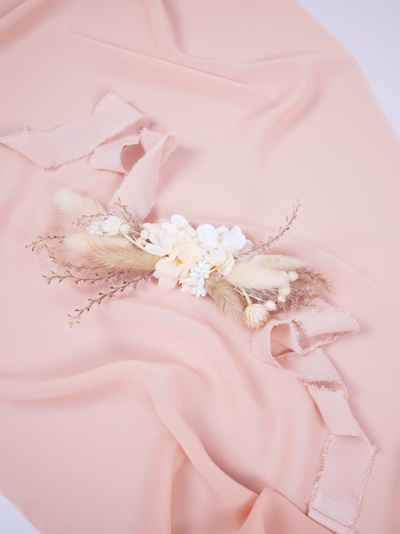 corsage is lying on pink organza