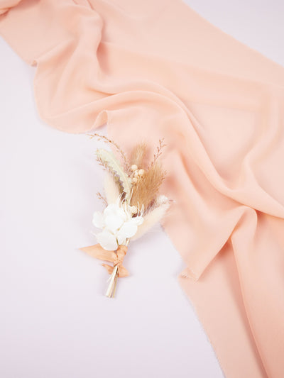 boutonniere is lying on white background and pink organza