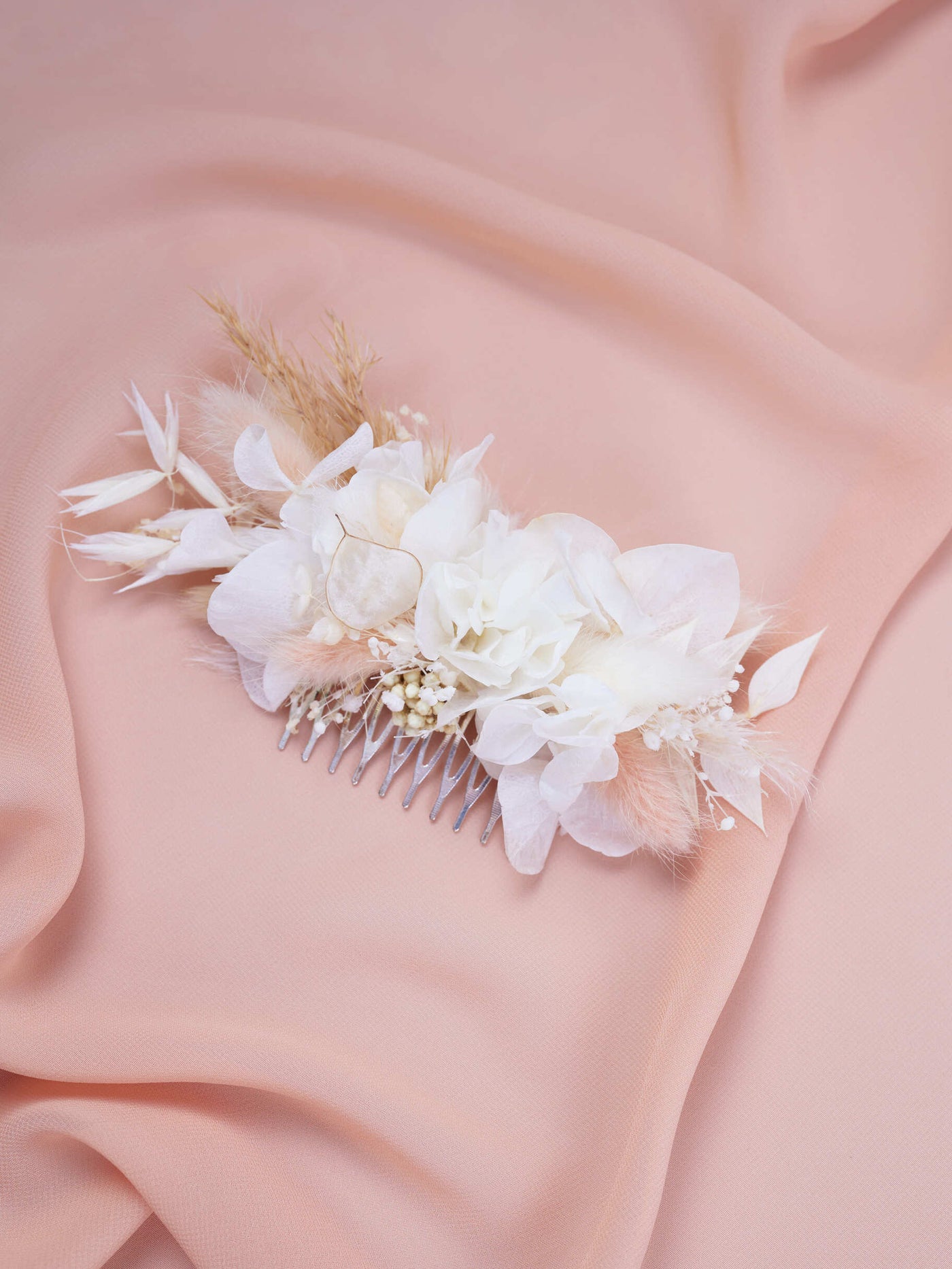 wedding comb is lying on pink organza