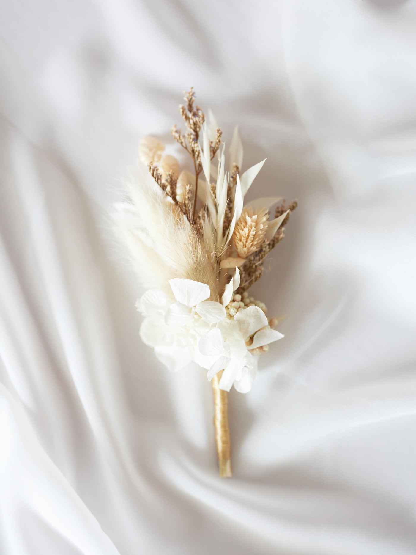 boutonniere is lying on white organza